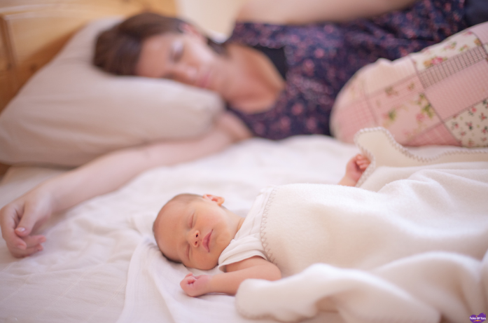 Newborn baby sleeping peacefully beside parent, showing gentle newborn care during the first precious weeks