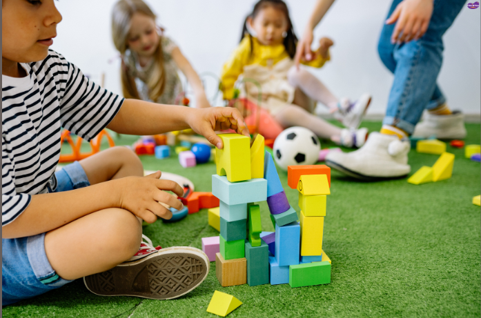 Child stacking colorful building blocks on grass, brain-boosting toys for children that improve creativity and problem-solving skills.