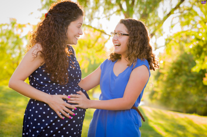 Pregnant woman feeling her baby’s first kick, a magical moment from the best parts of pregnancy.