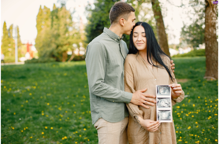 Expecting mother proudly holding her growing baby bump, celebrating her pregnancy.
